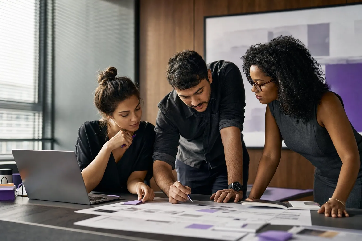 Equipe revisando wireframes de produto impressos em uma mesa